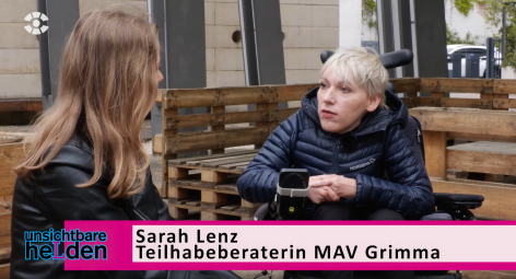 Sarah Lenz spricht mit einer:m Journalist:in im öffentlichen Raum.